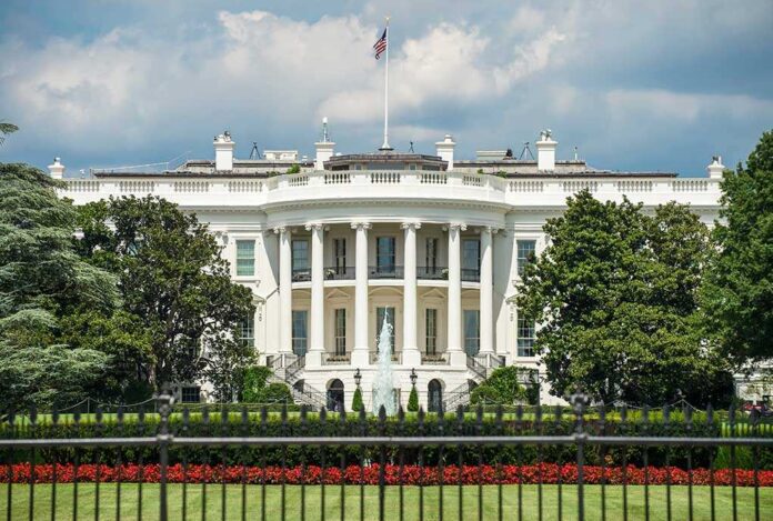 1198847647 featured image White building with columns behind a black fence.