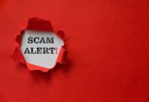 Scam alert text revealed through torn red paper