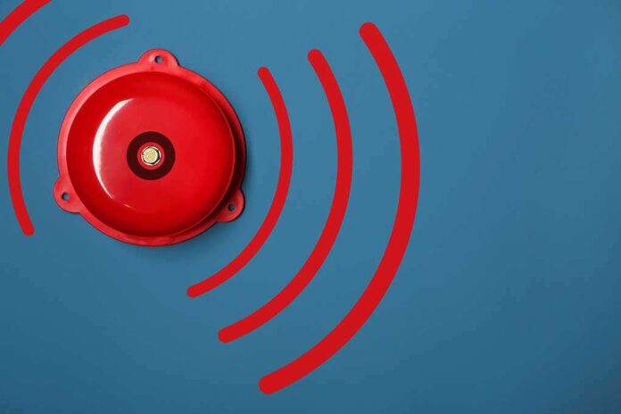 1311134939 featured image Red alarm bell on a blue background.