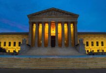 Illuminated SCOTUS building at dusk