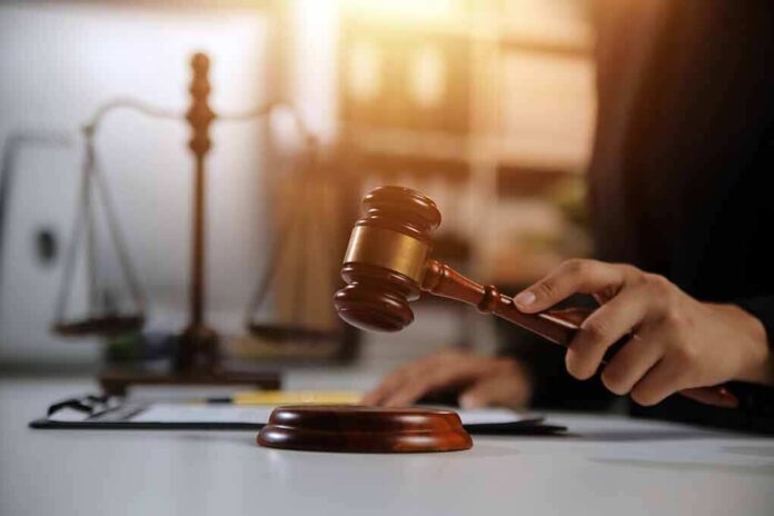 2478909667 featured image Hand holding gavel with scales in background