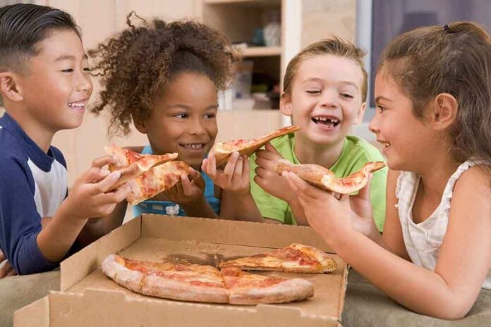 15488149 featured image Children happily eating pizza together