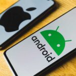 Android and Apple smartphones on a wooden table