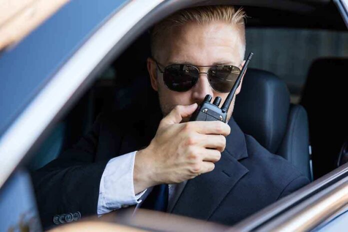 561916870 featured image Man in suit using walkie talkie in car