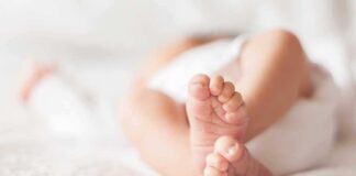 Close-up of baby feet lying on blanket