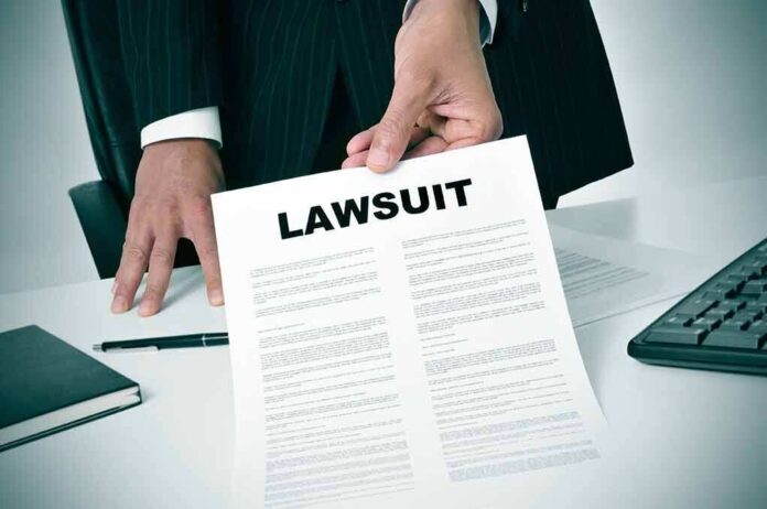 189871757 featured image Person holding a document titled LAWSUIT in office