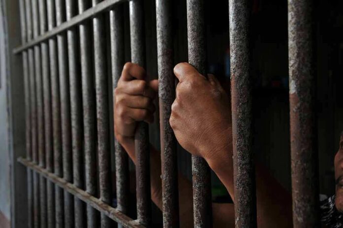 2452368639 featured image Hands gripping prison cell bars tightly