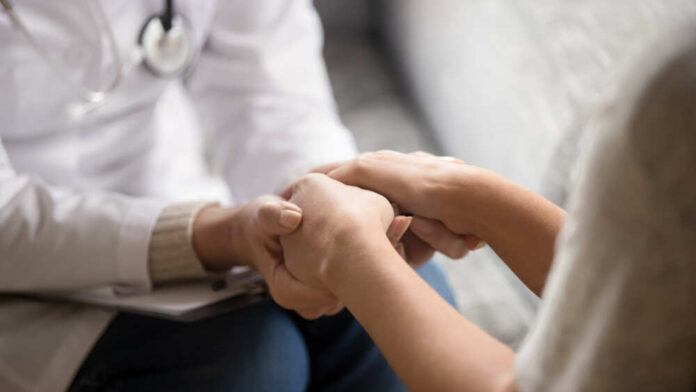 Doctor holding patients hands for support