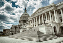 Capitol building with columns and cloudy sky