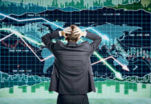 Person in front of falling stock market graph