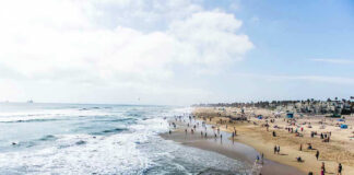 Crowded beach with waves and people enjoying sun
