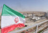 Iranian flag near an industrial gas refinery