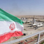 Iranian flag near an industrial gas refinery