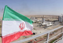 Iranian flag near an industrial gas refinery