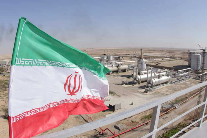 Iranian flag near an industrial gas refinery