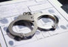 Handcuffs on fingerprint form with fingerprints visible