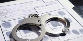 Handcuffs on fingerprint form with fingerprints visible