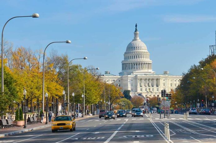 View of the Capitol building in Washington with autumn trees lining the street