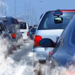 Traffic jam with cars emitting exhaust fumes on a city road