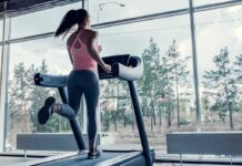 LA Fitness Scandal — Millions Trapped in Memberships A woman running on a treadmill in a gym with large windows
