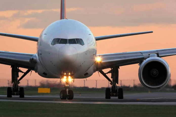 Airplane on runway during sunset.