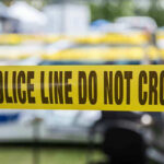 Yellow police line tape with Do Not Cross.