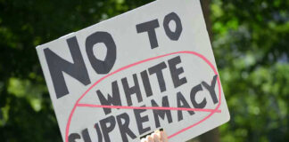 Sign saying No to white supremacy with red circle.