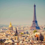 A panoramic view of Paris featuring the Eiffel Tower and a golden dome
