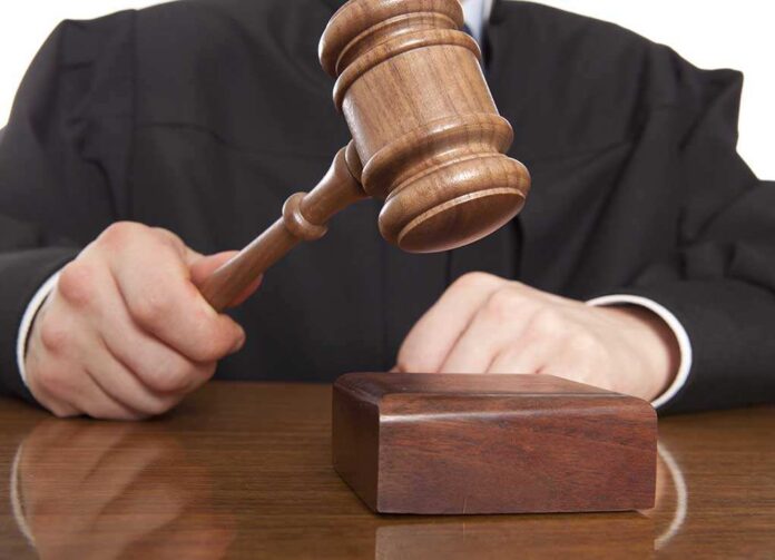 shutterstock_166657157.jpg A judge holding a gavel above a wooden block
