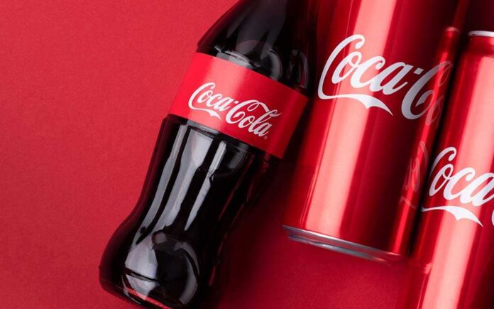 Coca-Cola bottle and cans on a red background