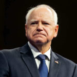 Man in suit with a U.S. flag pin.