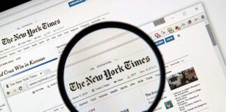 Magnifying glass over The New York Times website.