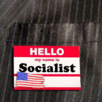 Hello my name is Socialist name tag on suit.
