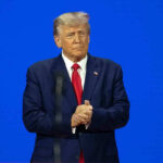 Man in a suit with a blue background.