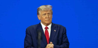 Man in a suit with a blue background.