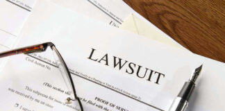 Lawsuit papers with glasses and pen on table.