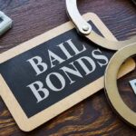 A bail bonds sign with handcuffs and stacks of cash