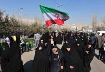 Missile Strike Wipes Out 175 Kids – Trump In Coverup! Group of women in black attire marching with an Iranian flag