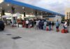 People waiting in line at a gas station with fuel containers