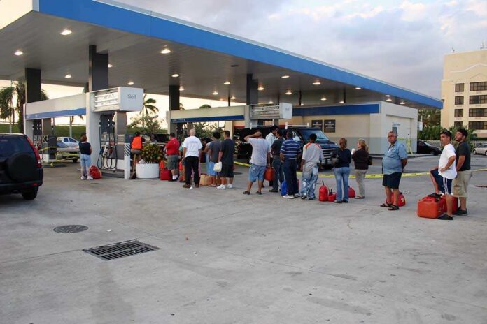People waiting in line at a gas station with fuel containers