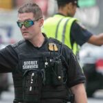 Suspect ARRESTED After BREACH During King Charles Visit! A Secret Service agent directing traffic in an urban setting