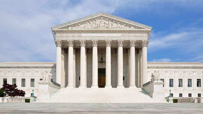 shutterstock_132568517.jpg Front view of the Supreme Court building with large columns and steps under a blue sky