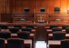 Empty courtroom with wooden benches and judges bench.