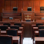 Weinstein Retrial Chaos: Jury Deadlock Again! Empty courtroom with wooden benches and judges bench.