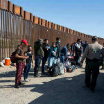 You Won’t Believe What Illegals Are Getting For Free Now! Border patrol agents interact with a group of people.