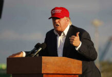 Look Who Introduced Trump at a Rally And Libs Were Furious! Person speaking at a podium wearing a red hat.