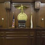 Interior of a courtroom featuring a judges bench and American flag