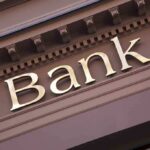 Trump TRANSFORMS Immigrant Bank Rules Close-up of a bank sign with gold lettering
