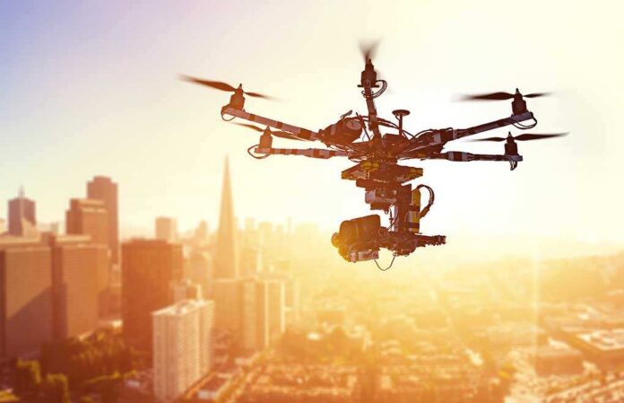 A drone flying over a city skyline during sunset