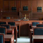 Ninth Circuit Judge CHARGED In Shocking Assault Case! Empty courtroom with wooden furnishings and judges bench.